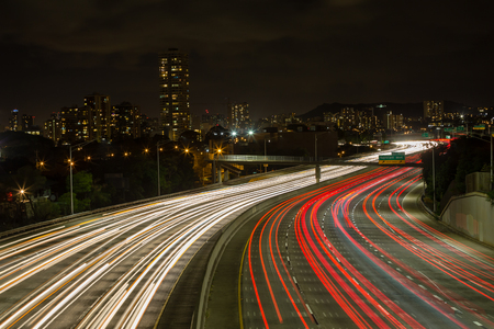 Light trails of vehicles on the Kapiolani exit to the motorway looking towards lights of Waikiki,...