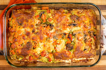 Freshly oven baked homemade vegetable lasagne with cheese in a glass oven dish viewed close up from aboveの写真素材