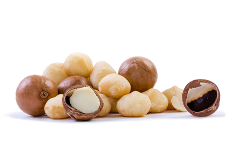 Pile of fresh macadamia nuts rich in nutrients with some whole shelled nuts, some nuts still in their shells and a few halved with loose shells on a white backgroundの写真素材
