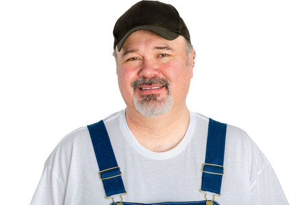 Portrait of cheerful man wearing cap with dungarees against white backgroundの写真素材