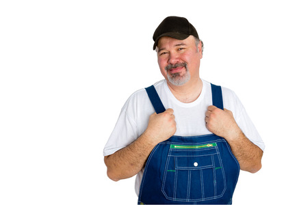 Portrait of smiling man wearing dungarees and cap standing against white backgroundの写真素材