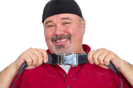 Happy middle-aged male airline passenger smiling after clicking the buckle on his safety belt holding it up on viewの写真素材
