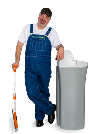 Happy confident capable water softener installer standing leaning on his product smiling in a concept of trustworthy business over whiteの写真素材