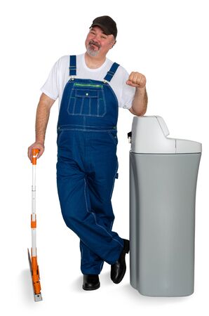 Workmen with a water softener ready to install the tank smiling and making a fist to show his motivation and confidenceの写真素材