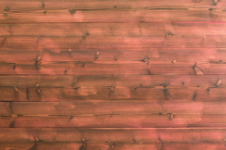 Red wooden plank wall background with visible knots in wood and black marks along grain. Includes copy space.の写真素材