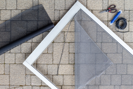 Repairing screen storm porch door with new materialの写真素材