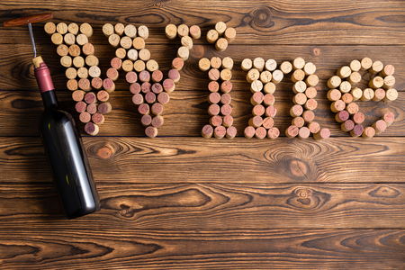 Wine lettering arranged of corks with bottle and corkscrew against wooden backgroundの写真素材