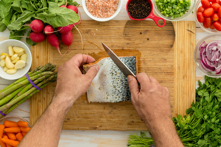 Man preparing a fresh salmon fillet for cooking