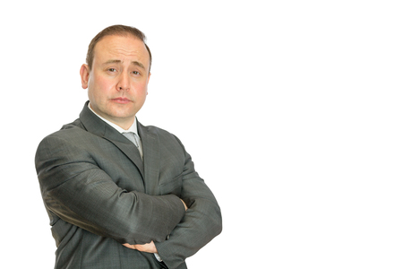 A perplexed-looking, stern businessman with crossed arms on a white  with copy space.の写真素材