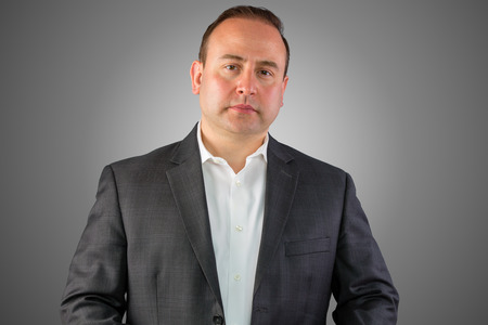 A portrait of a unhappy, stern business man portrait with a grey  and copy space.の写真素材