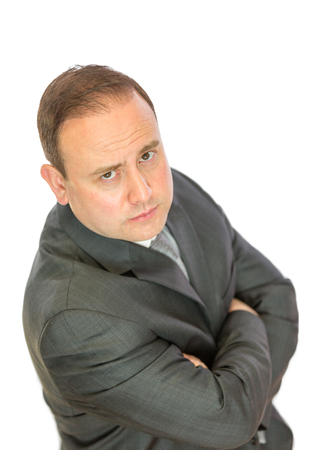 A serious-looking, concerned businessman with crossed arms on a white  with copy space.の写真素材