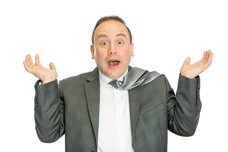 A portrait of a funny, surprised business man in suit shrugging with a white  and copy space.の写真素材