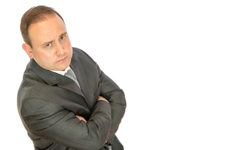 A serious-looking, concerned business manager with folded arms on a white  with copy space.の写真素材