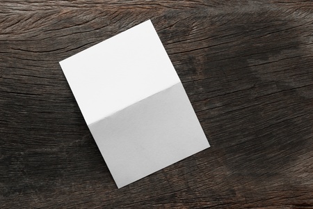 Blank portrait mock-up paper. brochure magazine isolated on brown wooden table, changeable background / white paper isolated on woodの写真素材