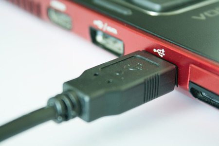 USB Cable connected in a black laptop - on white background