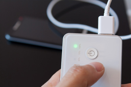 Smartphone is charging with power bank while it standbyの写真素材