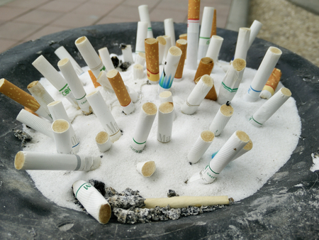 Bangkok,Thailand-Mar 07,2017:Cigarette butt cigarette on Ashtray with sand and cigarette stubs outdoorsのeditorial素材