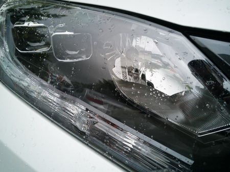 Closeup headlights of a car with raindrop.Car exterior detail