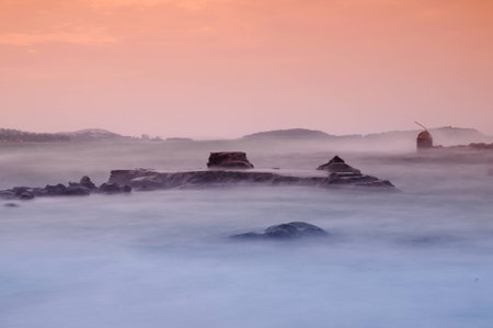 Mysterious rocks in the ocean on the horizon after sunsetの写真素材