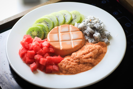 Thai tea pudding surrounded by various friutsの写真素材