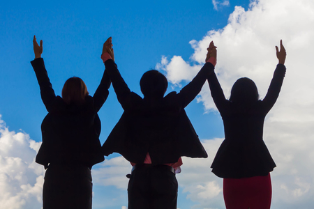 Business team hold hands up to show their success.の写真素材
