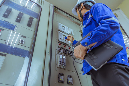 Male engineers are checking the electrical system by program in laptop.