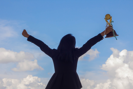 Businesswoman holding award trophy for show their victory.の写真素材