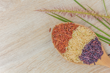 Red rice, white rice, purple rice are combined in a wooden spoon in equal proportions., Healthy and Non-Toxic Rice.の写真素材
