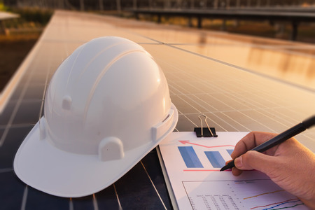 Engineers are examining the performance graph of energy production from solar panels that are...