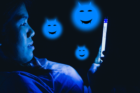 Women she played the smart phone in the dark light and the blue light has a negative effect on the eyes.の写真素材