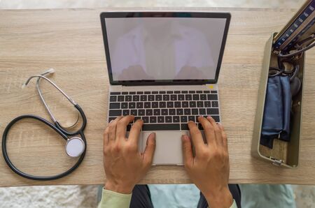 The doctor uses a laptop to diagnose the disease, record the patient's history and prescribe...