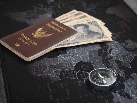 The young businesswoman prepares a passport and money and Necessary equipment, he is planning to travel using the map to choose countries to travel.の写真素材