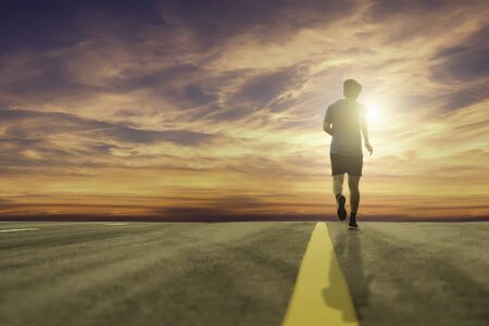 Low-angle shots of runners running on the street in the evening with orange sunlight, the concept of...