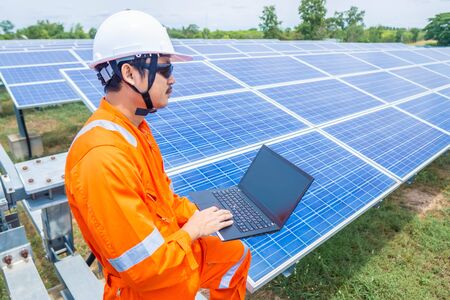 Engineers upload data of power energy to a laptop for checking the performance of the solar panel to confirming systems working normally. Concepts professional engineer for the Solar cell power plant.の写真素材