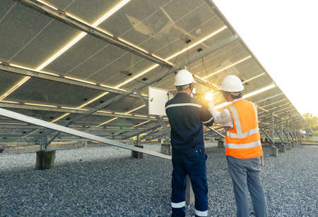 Technician with engineer are check the performance of the solar panels in the solar plant,...