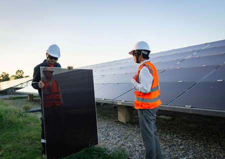 Technician is lifting the solar cell to replace the damaged one, Alternative energy to conserve the world's energy, Photovoltaic module idea for clean energy production.の写真素材