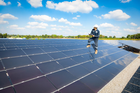 Technician stand on solar panel to check the operation of the solar farm systems, Alternative energy...