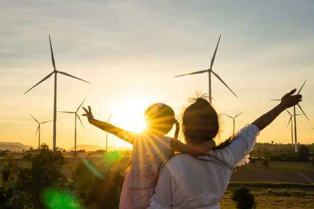 Wind turbines are alternative electricity sources, the concept of sustainable resources, People in the community with wind generators turbines, Renewable energy.の写真素材