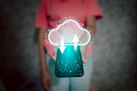 Woman holding a telephone with a cloud icon, symbol of personal data collection backup on the internet. the concept of cyber information data and privacy on high technology in the present and future.の写真素材