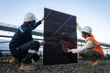 Technician is lifting the solar cell to replace the damaged one, Alternative energy to conserve the world's energy, Photovoltaic module idea for clean energy production.の写真素材