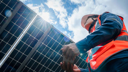 Low angle view of solar farm(solar panel) with engineers check the operation of the system, Alternative energy to conserve the world's energy, Photovoltaic module idea for clean energy production.の写真素材
