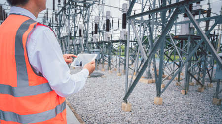 Engineers are checking the operation of the system by laptop, weekly check the system of the power distribution station for errors in the distribution electric system.の写真素材