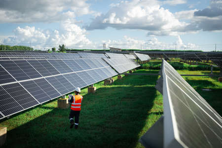 Technicians are checking the operation of the solar power plant equipment so that the power generation can operate at full capacity. Alternative energy to conserve the world's energy.の写真素材