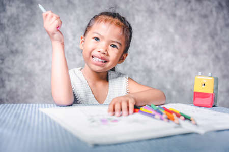 A girl learning to paint on a book She is passionate and fun in learning about art, concepts for learning about colors, and training the hand muscles.の写真素材