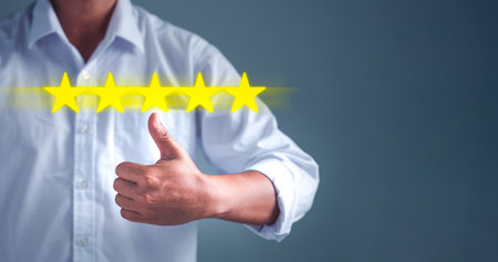 Business people are thumbs up as a sign of excellence with the virtual screen on the star icon to...