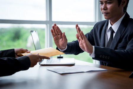 Businessman with raised hands as a stop, demanding bribes for business benefits, offenses in public and private organizations must be prosecuted by law. Being arrested for breaking the law.の写真素材