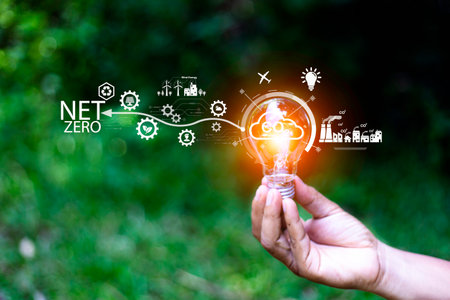 Net zero concept. Hand holding bulb with net zero icon. It is surrounded by a clean energy icon. Net...