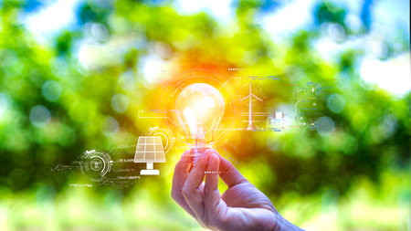 green energy concept help reduce global warming.Hand holding natural background light bulb on green leaf with clean energy icon around it. Carbon dioxide emission in industry zero carbon concept.の写真素材