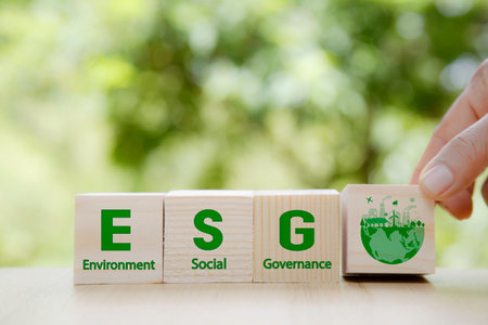 ESG icon in wood on green background. Investing in environmental, social, governance or Invest ESG in industry. ESG investment. Green renewable energy concept. Innovation technology ecology energy.の写真素材