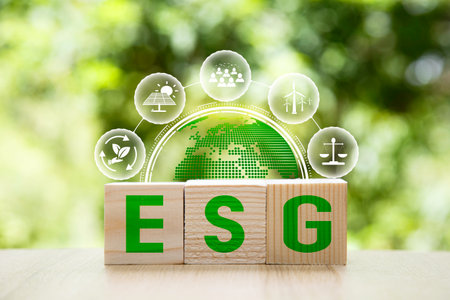 ESG icon in wood on green background. Investing in environmental, social, governance or Invest ESG...